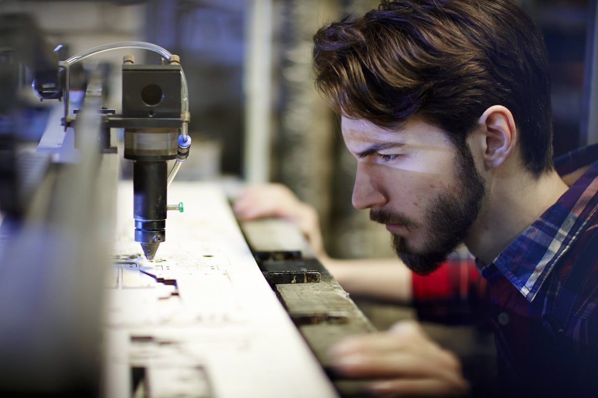 Lasersheet laser cutter maker inspecting machine while cutting wood